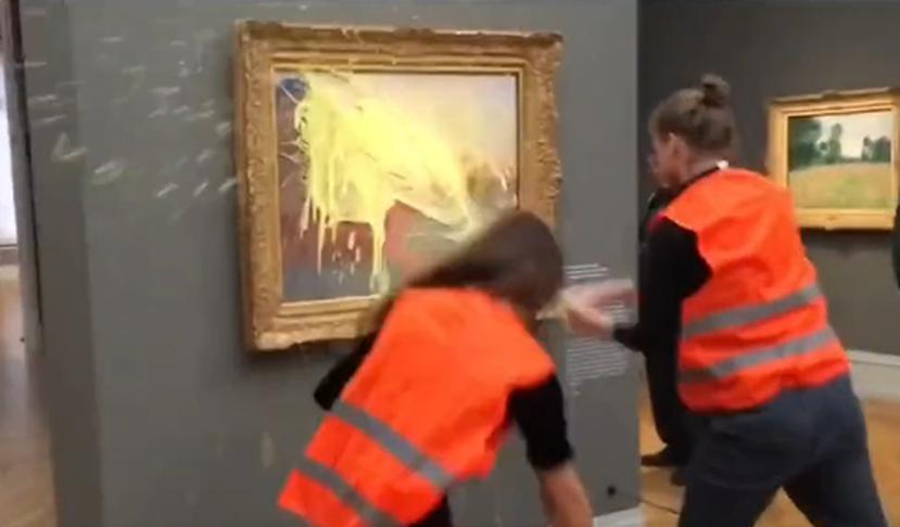 Momento en que dos activistas lanzan un puré de papas contra un cuadro de Monet en Berlín, Alemania.