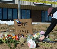 Elijah Newcomb de Colorado Springs coloca flores cerca de un club nocturno gay en Colorado Springs, Colorado, donde ocurrió una masacre el sábado por la noche.