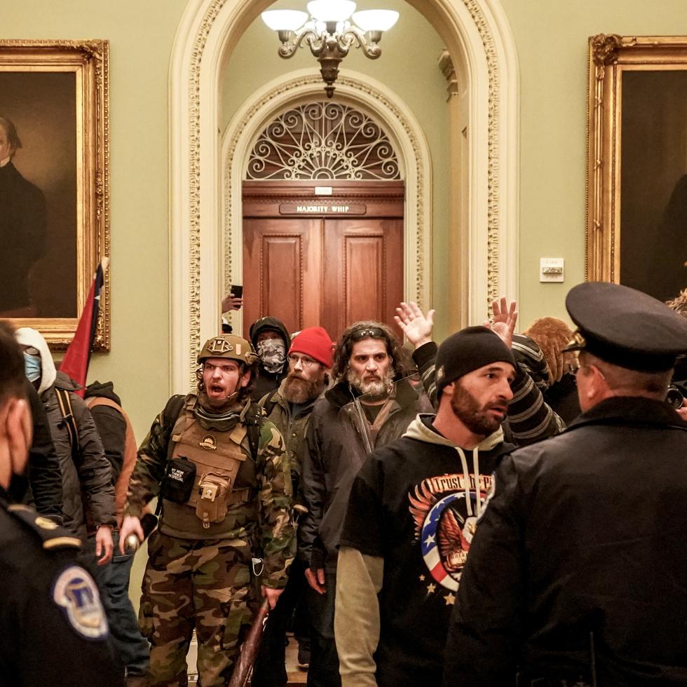 **EMBARGO: No electronic distribution, Web posting or street sales before FRIDAY 3:01 A.M. ET JAN. 29, 2021. No exceptions for any reasons. EMBARGO set by source.** FILE -- Rioters, including Robert Gieswein, helmeted, and Dominic Pezzola, sunglasses in hair, confront Capitol Police officers near the U.S. Senate chamber, inside the Capitol in Washington, Jan 6, 2021. A number of members of Congress have links to organizations and movements that played a role in the Jan. 6 assault on the Capitol. (Erin Schaff/The New York Times)