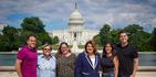 Cinco de los cabilderos por la estadidad posan con la comisionada residente frente al Capitolio federal en Washington DC.