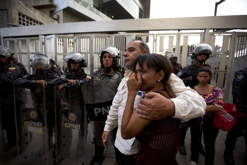 Miembros de la oficina del concejal Alberto Albán se abrazan a las afueras de las instalaciones del Servicio Bolivariano de Inteligencia Nacional (SEBIN) en Caracas, Venezuela. (AP)