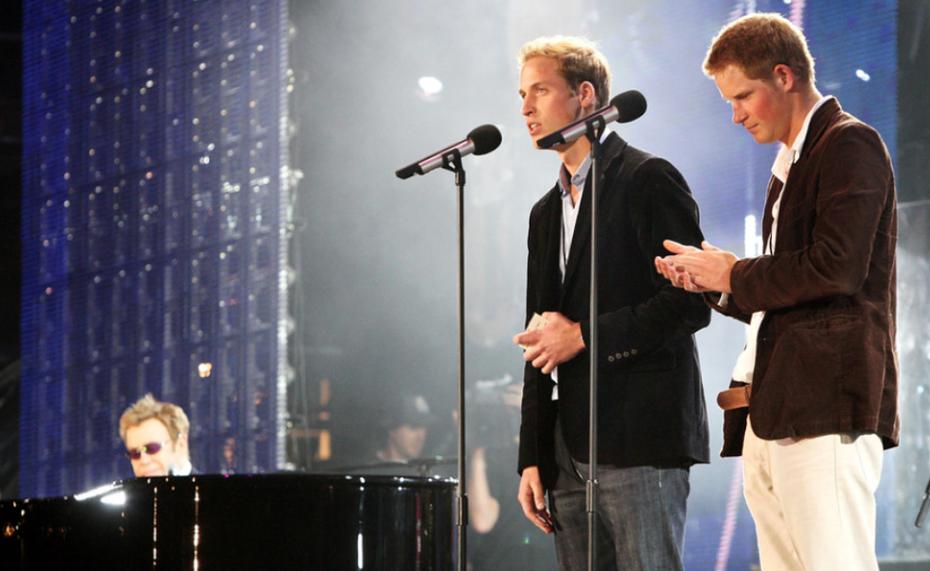 El príncipe William (izquierda) y Harry hablan durante un concierto de Elton John, en 2007. (AP)