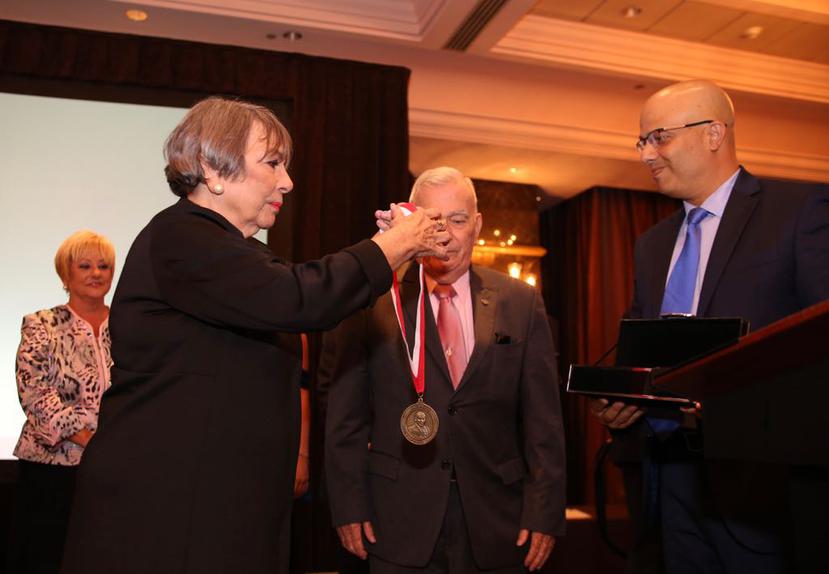 María Victoria 'Melo' Muñoz hace entrega de la medalla junto a Héctor Ferrer, presidente del PPD.