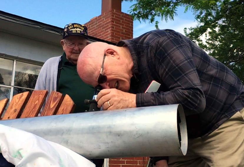 Padre e hijo construyen un nuevo telescopio para observar el eclipse. (AP)