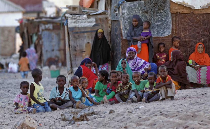 Mujeres y niños somalíes se reúnen al atardecer en una calle de arena en el antiguo pueblo de Eyl, en el estado semiautónomo somalí de Puntland. (AP)