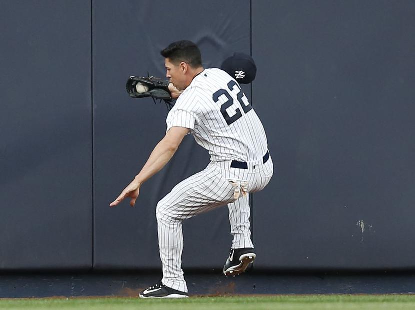 Jacoby Ellsbury, jardinero central de los Yankees de Nueva York, se estrella contra la barda al atrapar un elevado del venezolano Alcides Escobar, de los Reales de Kansas City. (AP)