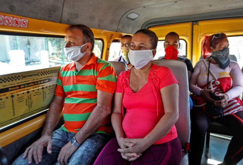 Pasajeros de un autobús usan mascarillas este domingo en La Habana, Cuba. (EFE)
