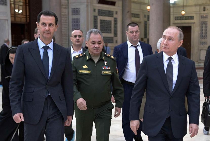 El presidente de Rusia, Vladimir Putin (derecha), su homólogo sirio, Bashar Assad (izquierda), y el ministro ruso de Defensa, Sergei Shoigu (centro). (AP)