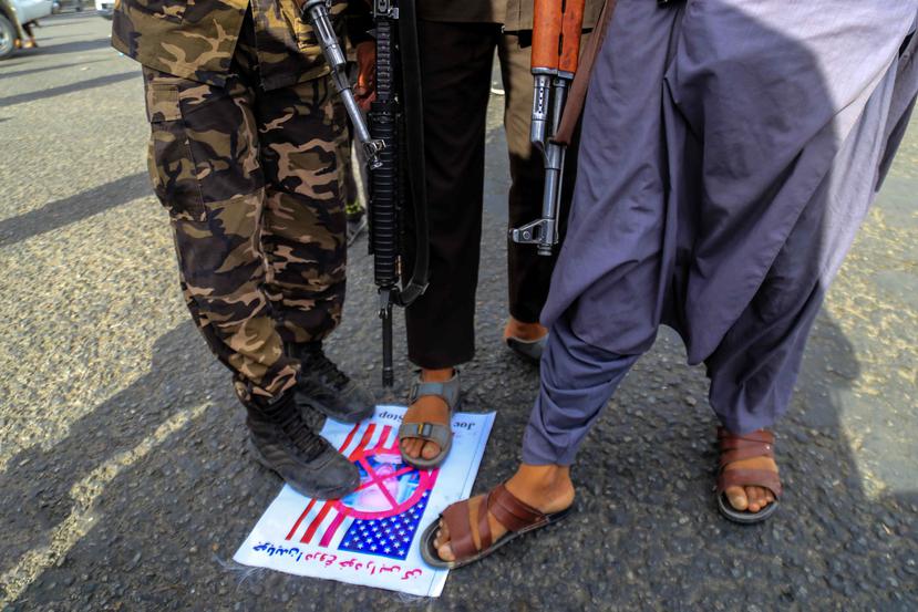 Imagen de archivo en la que se ve a unos talibanes pisando una foto de la bandera de Estados Unidos y su presidente, Joe Biden, en Kabul.