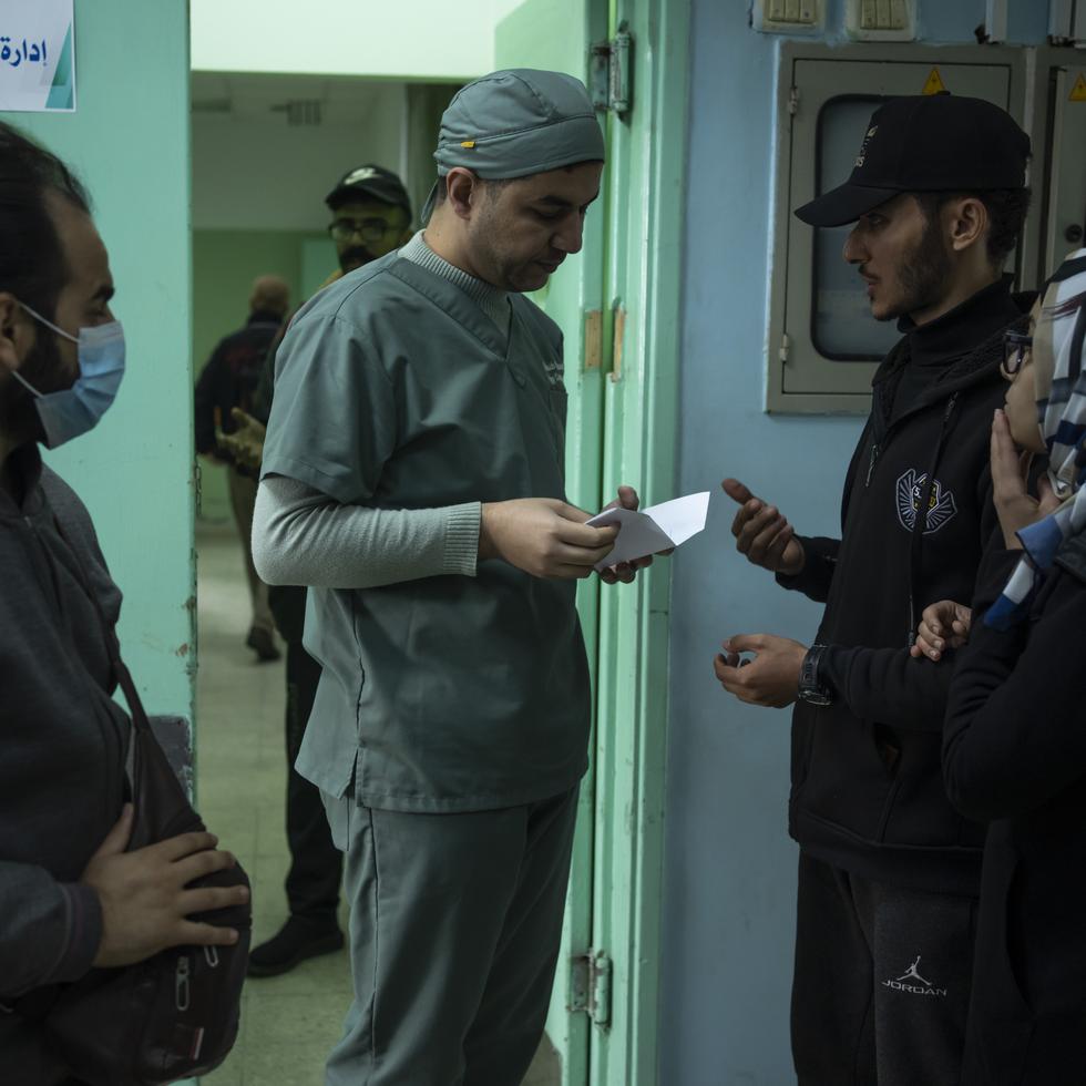 El médico Suhaib Alhamss, director del Hospital Kuwaití en Rafah, la ciudad más sureña de la Franja de Gaza, habla con pacientes afuera del departamento administrativo del nosocomio, el jueves 11 de enero de 2024.