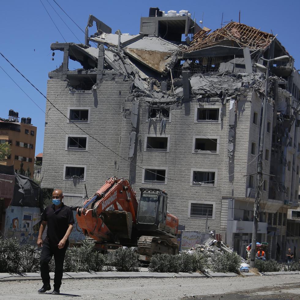 Un palestino pasa junto a un edificio golpeado por un ataque israelí en Ciudad de Gaza, el martes 18 de mayo de 2021. (AP Foto/Hatem Moussa)
