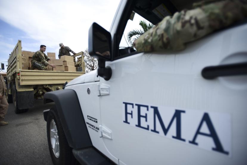 En esta fotografía de archivo del 5 de octubre de 2017, personal del Departamento de Seguridad Nacional entrega provisiones a residentes de la comunidad Santa Ana tras el paso del huracán María en Guayama, Puerto Rico. (AP/Carlos Giusti)