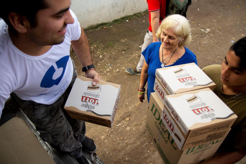 Arriba, un voluntario de Nilus reparte alimentos a una comunidad en Rosario, Argentina. (Suministrada)