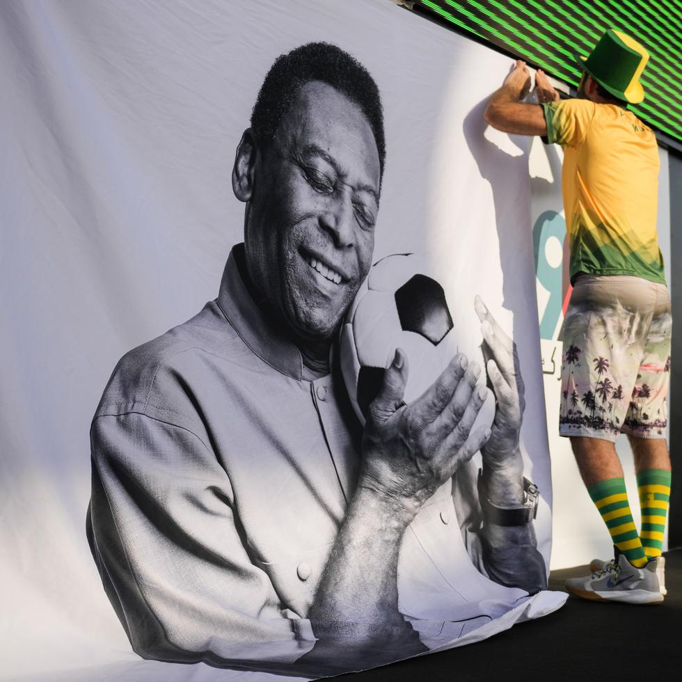 Un aficionado coloca un cartel de apoyo a Pelé en una fiesta de torcedores de Brasil.