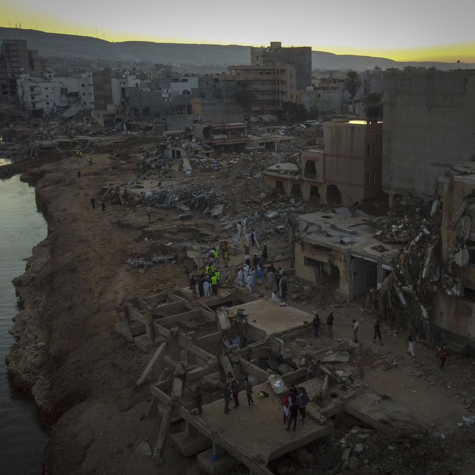 Varias personas buscan a víctimas de las inundaciones entre los escombros en Derna, Libia, el 15 de septiembre de 2023.