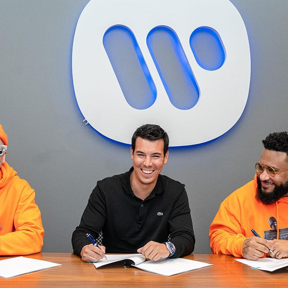 El presidente de Warner Music Latina, Alejandro Duque al centro, junto a los artistas Yandel, a la izquierda, y Ángel "El Gurú" Vera, a la derecha, durante la firma del convenio de alianza con Rapetón Approved.