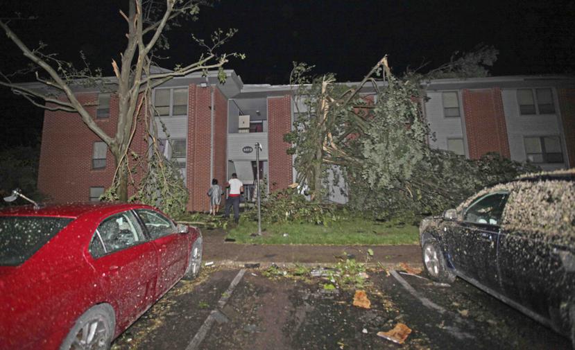 Vecinos caminando hacia su edificio de apartamentos Westbrooke Village, que resultó dañado por un tornado, el martes 28 de mayo de 2019 en Dayton, Ohio. (Doral Chenoweth III/Columbus Dispatch via AP)