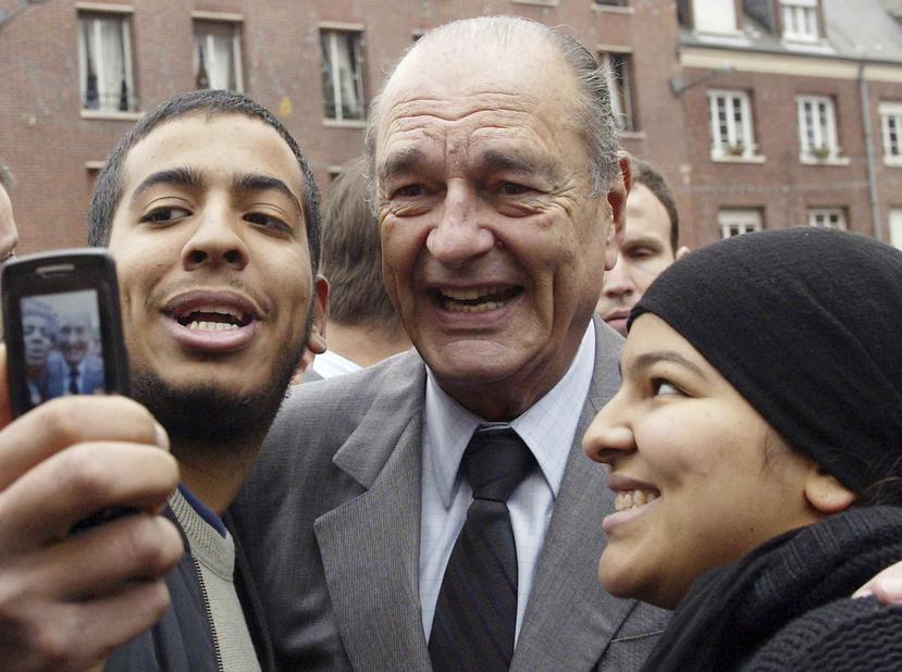 El expresidente de Francia, Jacques Chirac, posa con ciudadanos durante una visita a Amiens, en el norte de Francia, en 2006. (AP)
