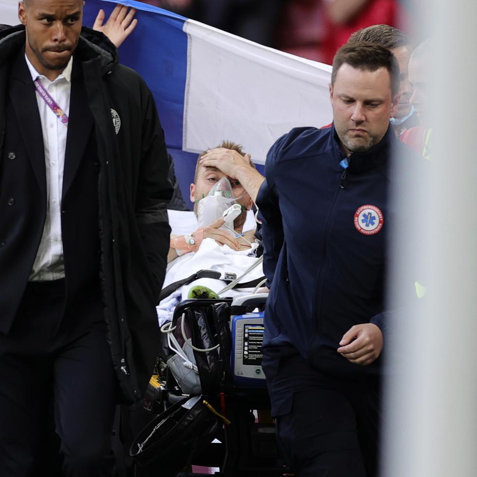 Paramédicos retiran en camilla al jugador danés Christian Eriksen, quien se desvaneció en un partido de la Eurocopa.