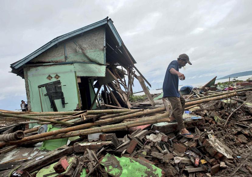 Un hombre busca entre los escombros que dejó el tsunami. (AP)