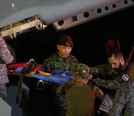 Personal militar baja en camilla a uno de los cuatro hermanos indígenas que pasaron 40 días desaparecidos en la selva tras un accidente de avión, en una base aérea del Ejército en Bogotá, Colombia, el 10 de junio de 2023. (AP Foto/John Vizcaino)