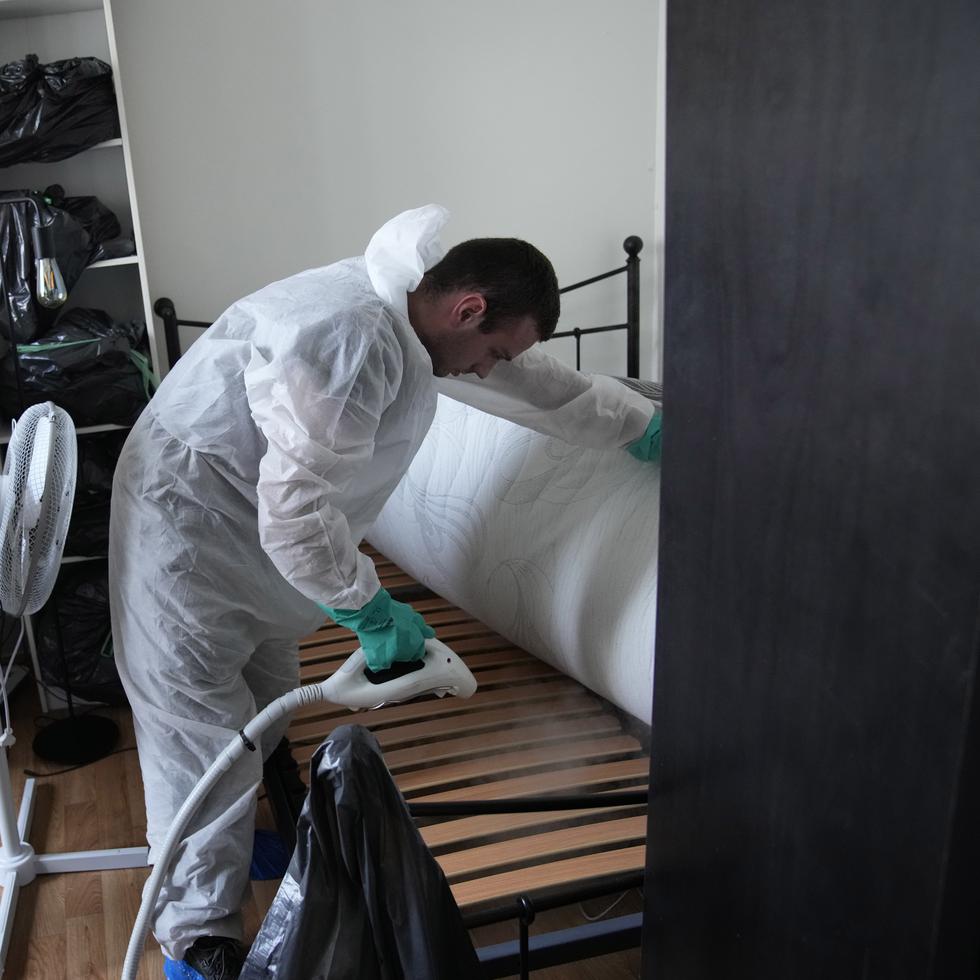 Lucas Pradalier, experto en control de plagas, rocía un vapor en una cama de un apartamento en París, el miércoles 4 de octubre de 2023 (AP Foto/Christophe Ena)