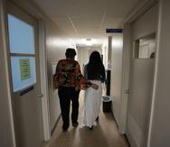 A 33-year-old mother of three from central Texas is escorted down the hall by clinic administrator Kathaleen Pittman prior to getting an abortion, Saturday, Oct. 9, 2021, at Hope Medical Group for Women in Shreveport, La. The woman was one of more than a dozen patients who arrived at the abortion clinic, mostly from Texas, where the nation's most restrictive abortion law remains in effect. (AP Photo/Rebecca Blackwell)
