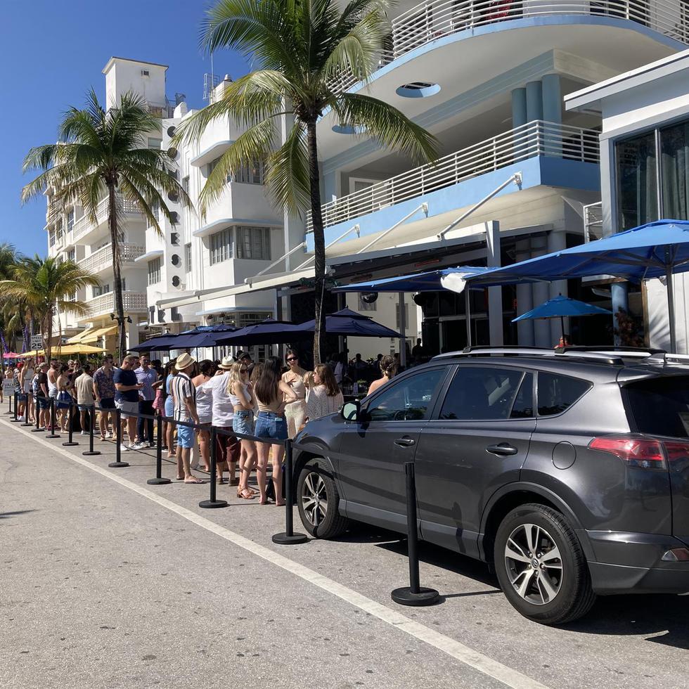 Varios jóvenes esperan para entrar a un establecimiento en la calle Ocean Drive, durante el Spring Break, en Miami.