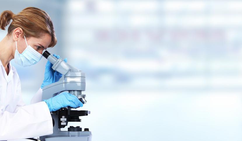 Una científica mira a través de un microscopio. (Shutterstock)