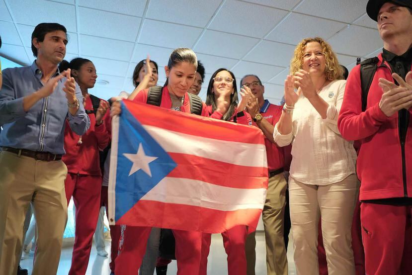 La armadora Pamela Rosado sostiene la bandera de Puerto Rico a su salida del terminal del Aeropuerto Internacional Luis Muñoz Marín.
