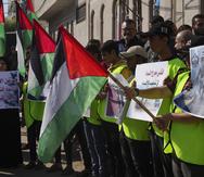 Simpatizantes de Hamas agitan banderas palestinas durante una manifestación en solidaridad con los habitantes palestinos de Cisjordania y Jerusalén, después de la jornada de oración en la mezquita de Salah elDein, en la principal avenida de la Ciudad de Gaza, el viernes 2 de diciembre de 2022.