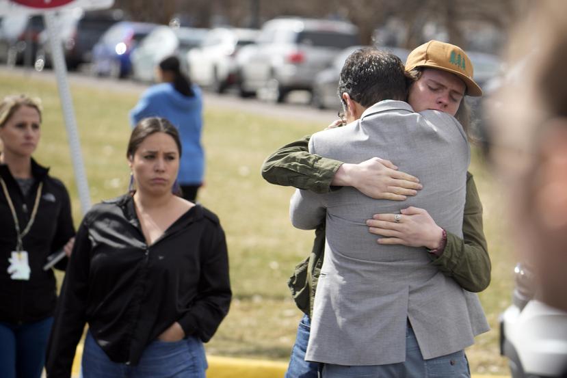 Un alumno, a la derecha, abraza a un padre al reunirse después de un tiroteo escolar en la escuela East High School, el miércoles.