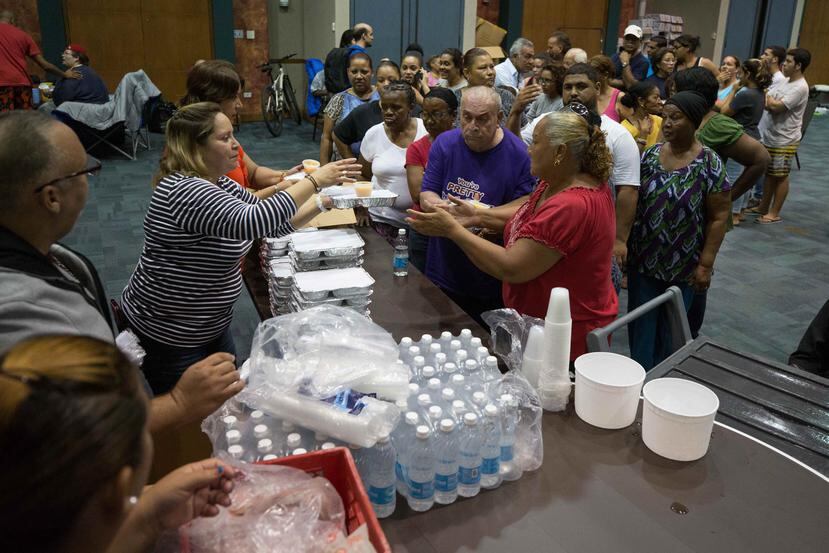 Refugiados en reciben sus alimentos en el Complejo Ferial de Ponce.