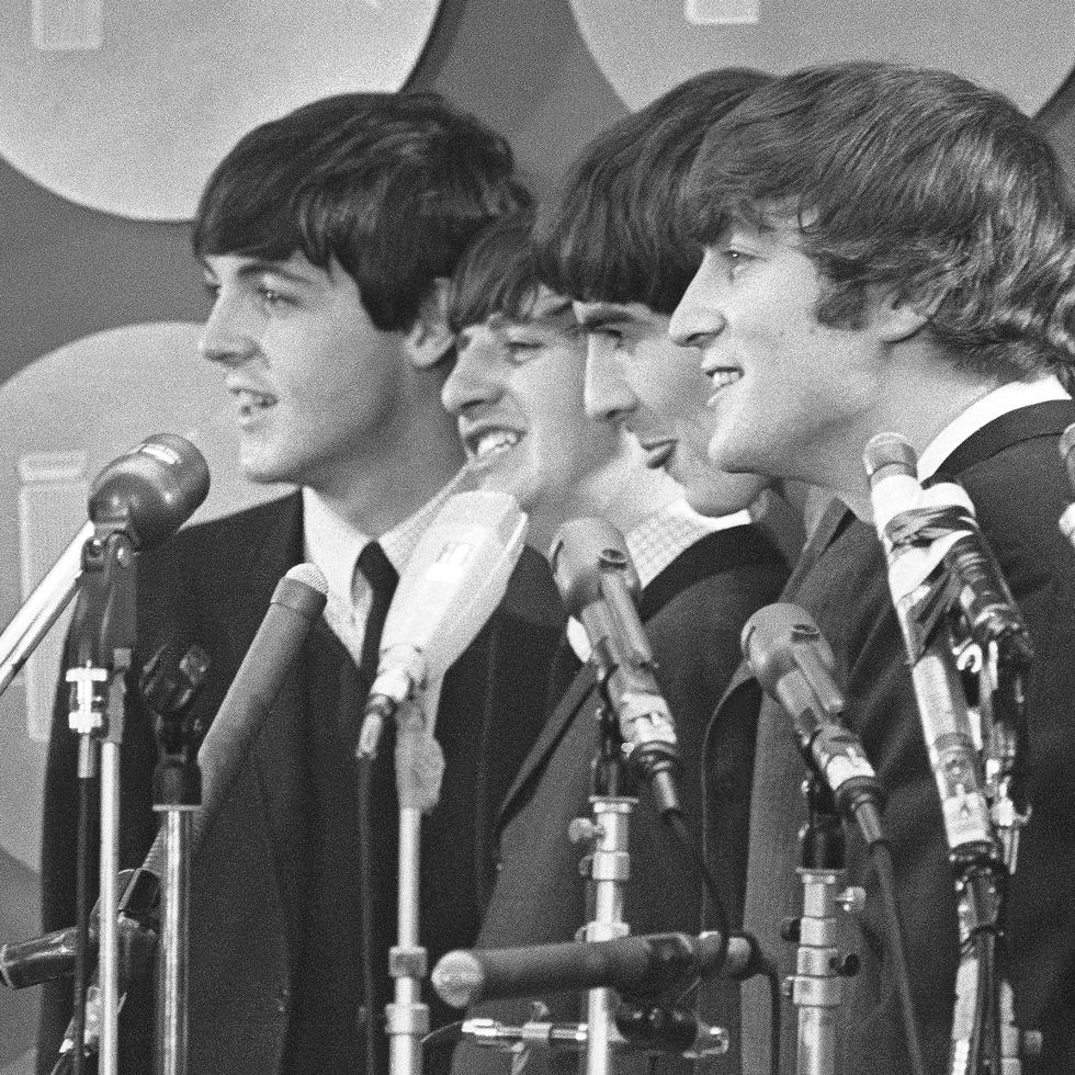 The Beatles hablan con medios de comunicación en el Aeropuerto Internacional Kennedy a su llegada el 7 de febrero de 1964 en Nueva York. (Foto AP, archivo)