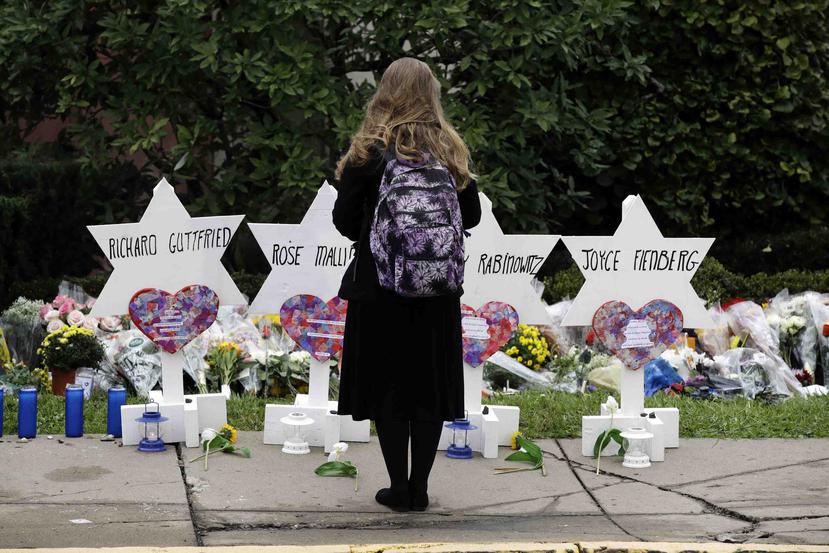 Una mujer observa Estrellas de David frente a la sinagoga Árbol de la Vida con los nombres de las personas asesinadas en un tiroteo en ese templo en Pittsburgh. (AP / Matt Rourke)