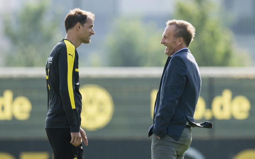 El presidente del Dortmund, Hans-Joachim Watzke (d), acompañado en esta foto por el entrenador Thomas Tuchel, expuso que retirar el equipo hubiera significado “una victoria para para los atacantes". (Archivo / EFE)