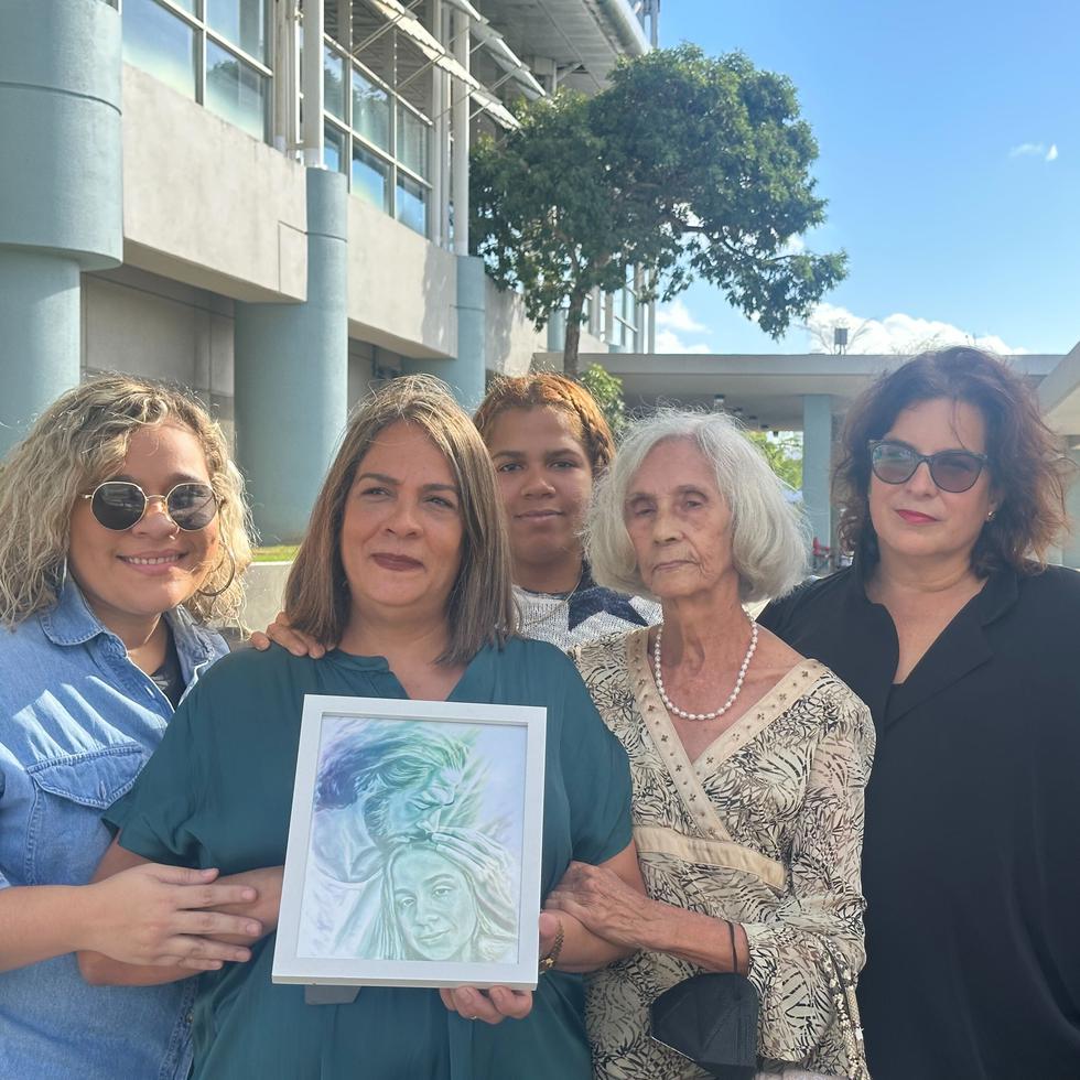 La madre de Lara Camila González, acompañada por varios miembros de su familia, carga una foto de su hija en las afueras del Tribunal de Primera Instancia de Bayamón.