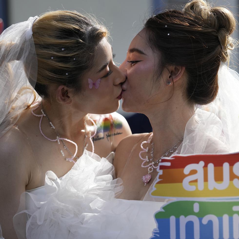 En esta imagen de archivo, dos mujeres se besan mientras sostienen un cartel en favor del matrimonio igualitario, durante un Desfile del Orgullo, en Bangkok, Tailandia, el 4 de junio de 2023.