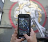 Una persona toma una foto del mural de Rafa Algarín durante "Santurce es Ley".