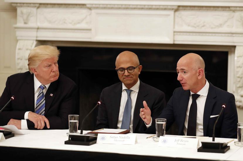 El presidente Donald Trump, izquierda, y el director general de Microsoft, Satya Nadella, escuchan al director general de Amazon, Jeff Bezos, en un panel sobre tecnología en la Casa Blanca en junio de 2019. (archivo)