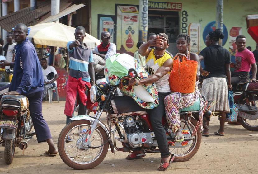 Un conductor de una motora taxi lleva una pasajera por las calles de Mbandaka, en República Democrática del Congo. (AP / Sam Mednick).