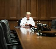 In this image released by the White House, President Donald Trump works in his conference room at Walter Reed National Military Medical Center in Bethesda, Md., Saturday, Oct. 3, 2020, after testing positive for COVID-19. (Joyce N. Boghosian/The White House via AP)