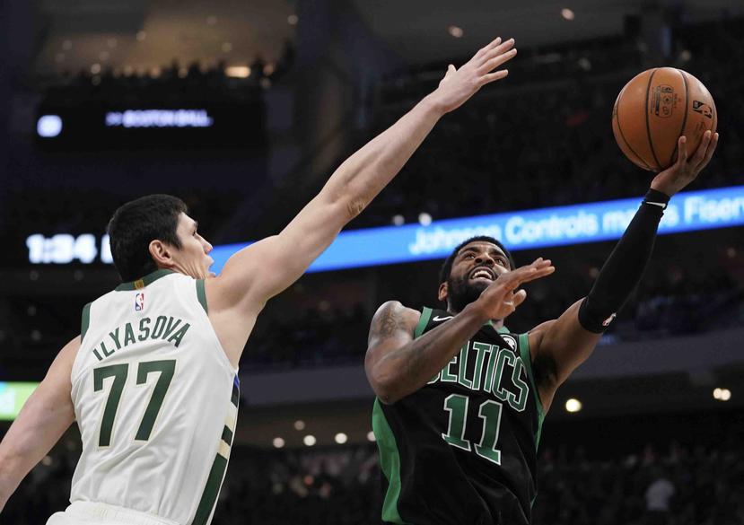 Kyrie Irving intenta evadir la defensa de Ersan Ilyasova rumbo al canasto en el choque entre los Celtics de Boston y los Bucks de Milwaukee. (AP / Morry Gash)