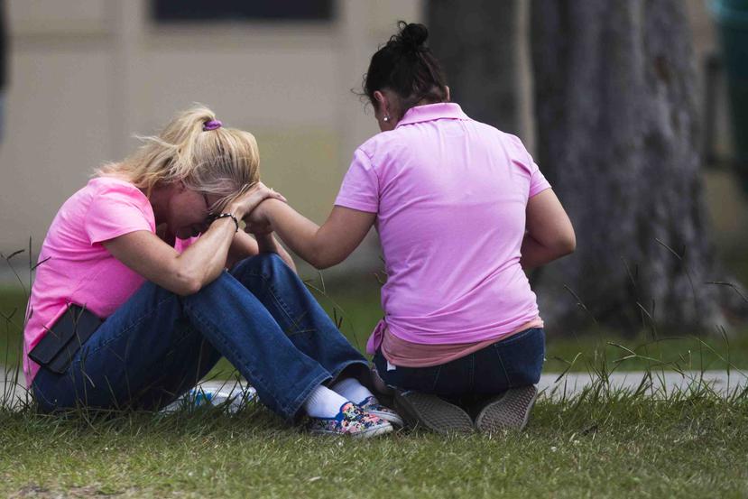 Dos mujeres oran tras un tiroteo en la secundaria Santa Fe el viernes 18 de mayo de 2018, en Santa Fe, Texas. (Marie D. De Jesus/Houston Chronicle vía AP)