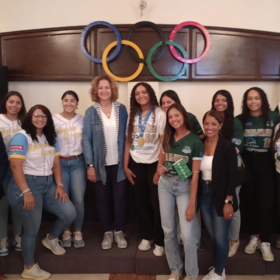 Ambos equipos posan para una foto junto a la presidenta del Comité Olímpico de Puerto Rico, Sara Rosario.