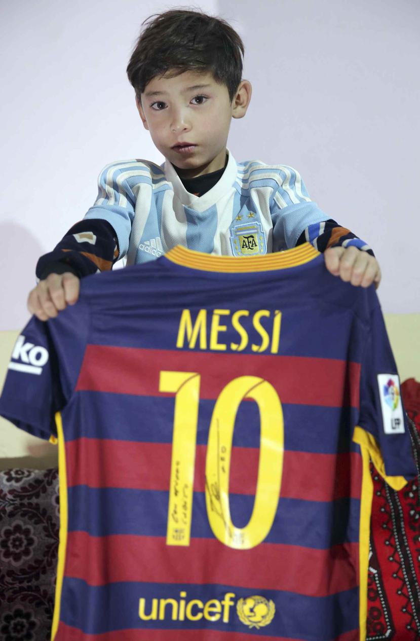 Murtaza Ahmadi, aficionado de Lionel Messi, muestra el autógrafo del astro argentino en una camiseta en la casa de unos familiares en Kabul, Afganistán el viernes 7 de diciembre de 2018. (AP)