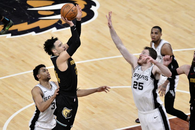 El alero de los Grizzlies de Memphis Dillon Brooks lanza el balón frente a Jakob Poeltl y Keldon Johnson, de los Spurs de San Antonio, en el encuentro del mini-torneo "play-in" de la NBA.