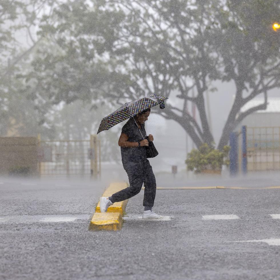 El Servicio Nacional de Meteorología (SNM) emitió este martes, 7 de mayo de 2024, un aviso y advertencia de inundaciones para varios pueblos ante el paso de una vaguada. En la foto, una persona cruza la calle cerca de Plaza Universitaria en el recinto riopedrense de la Universidad de Puerto Rico (UPR). 
