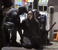 Una manifestante es arrestada por miembros de la policía de Portland durante la noche número 99 de protestas en la noche del viernes.
