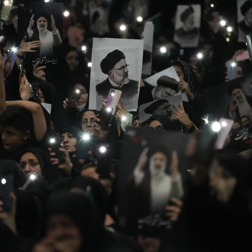 Dolientes sostienen carteles con la imagen del fallecido presidente iraní Ebrahim Raisi en la gran mezquita Imán Jomeini en Teherán, Irán. Los dolientes vestidos de negro iniciaron el martes varios días de funerales y procesiones por el fallecido presidente de Irán, el ministro de Exteriores y otros muertos en un choque de helicóptero, en una serie de actos dirigidos por el gobierno para homenajear a los muertos y dar una imagen de fuerza en un convulso Oriente Medio.
